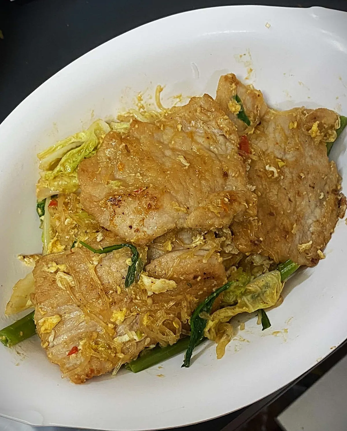 หมูผัดกับไข่และต้นหอมบนจานขาว มีผักกรอบอยู่ด้านล่าง