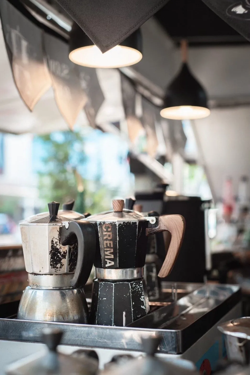 หม้อต้มกาแฟ Moka Pot หลายใบวางบนเตาในร้าน